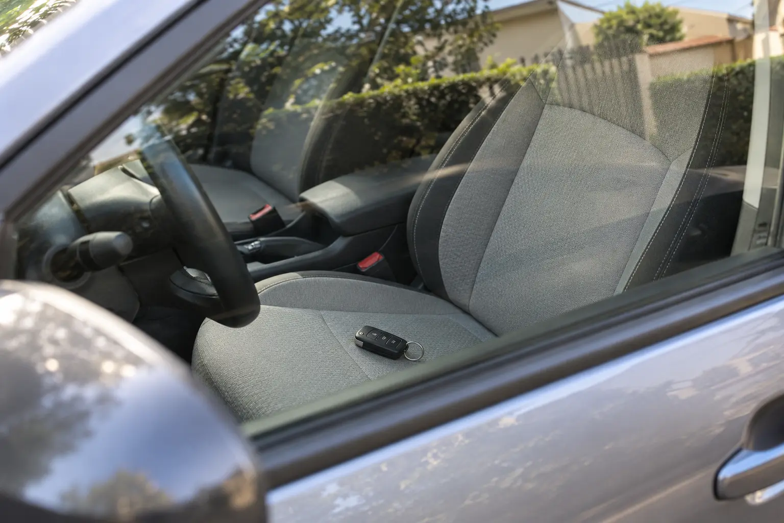Llave de vehículo sobre el asiento vista desde la ventana cerrada